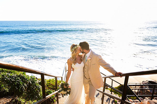 Newlyweds kiss in front of the ocean