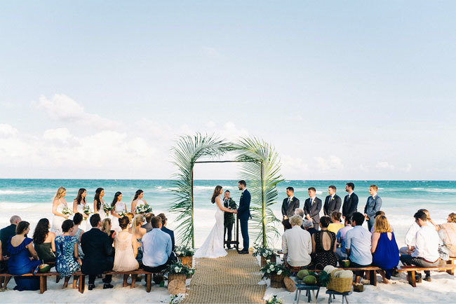 A bride and groom say their vows on the beach in Tulum, Mexico