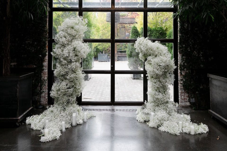 An open ceremony arch made entirely of baby's breath | 21 Hidden Wedding Fees