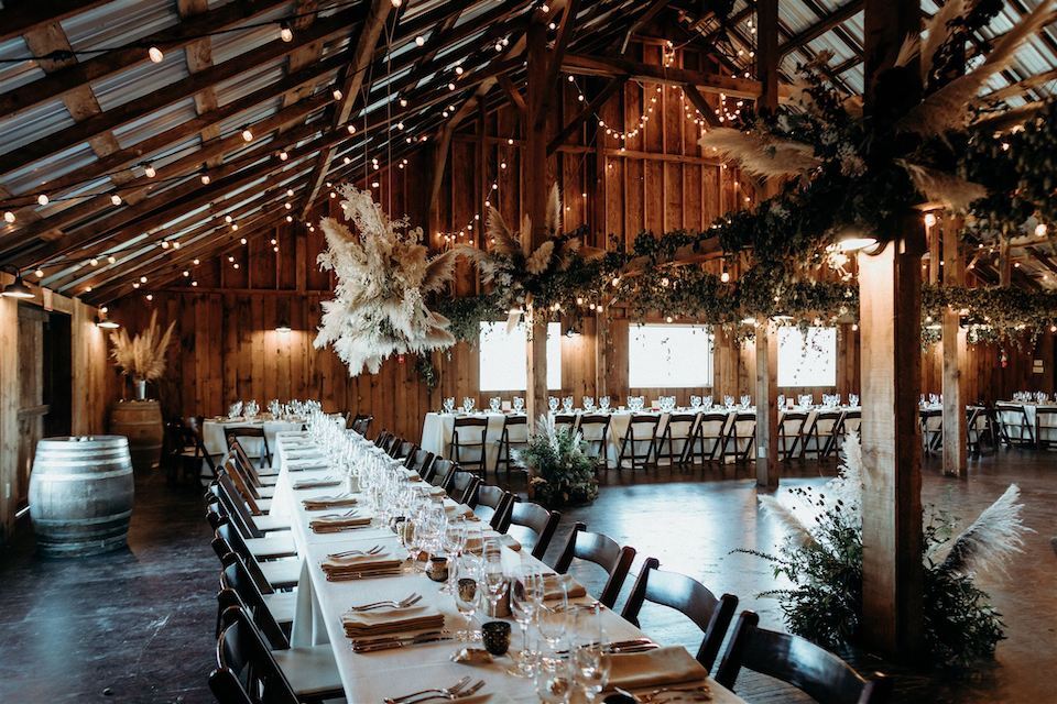 Stemple Creek Ranch barn wedding venue reception with long tables and hanging floral installations