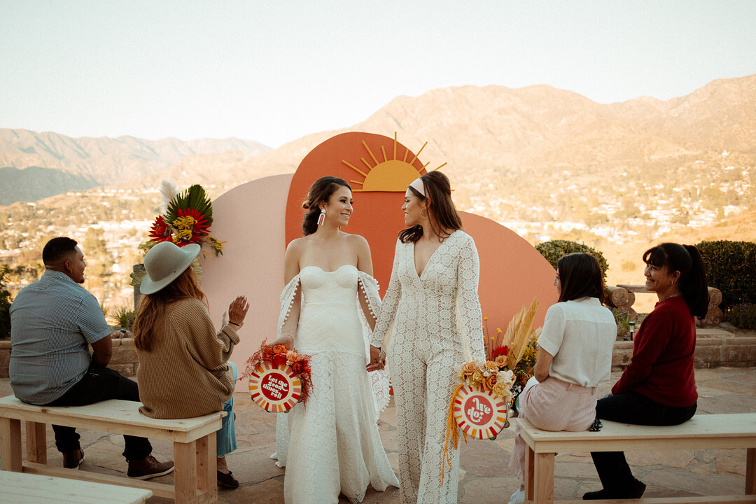 How To Brand Your Wedding | Two brides have an intimate microwedding with golden summer vibes and geometric backdrop