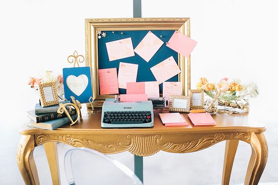 A desk with typewriter, notes, and wedding planning supplies