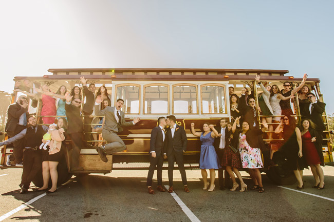 Grooms kiss in front of a San Francisco cable car | Questions to Ask your Wedding Photographer