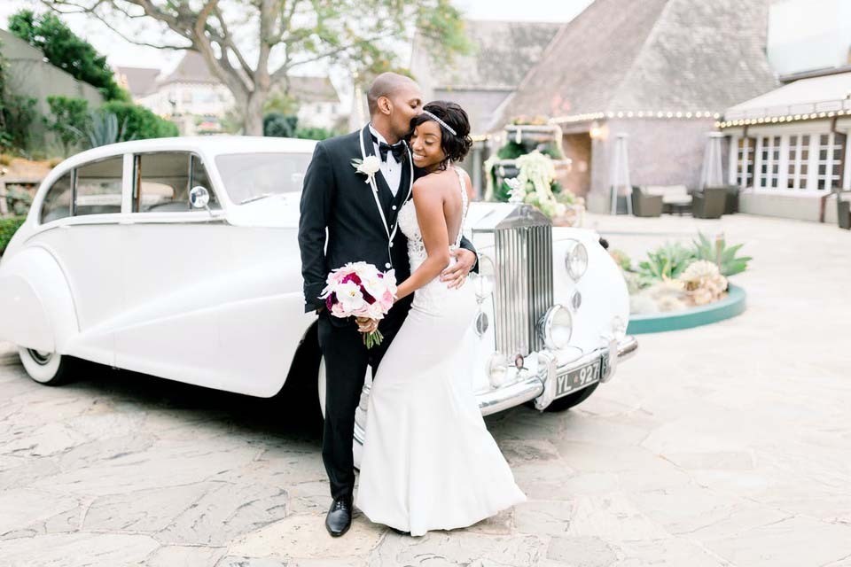 How To Determine Wedding Budget | Newlyweds in front of their vintage wedding getaway car