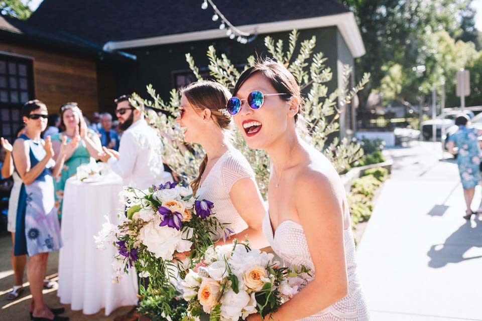 Percentages for Wedding Budget | Two brides in sunglasses enjoy their outdoor cocktail hour