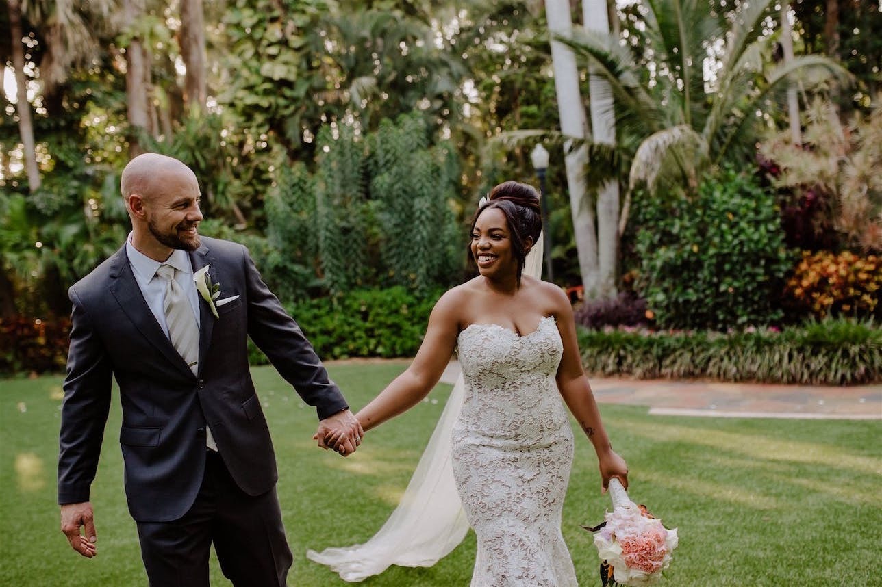 Newlyweds holding hands at Sunken Gardens | Ways to cut wedding costs