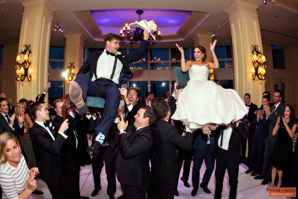 Guide for creating your wedding reception timeline | The couple hoisted into the air on chairs for the Jewish Hora Dance